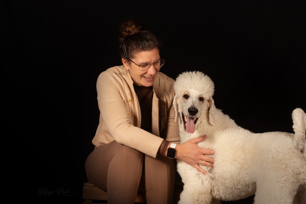Amandine Creten prodiguant des soins tout en douceur à un caniche royal